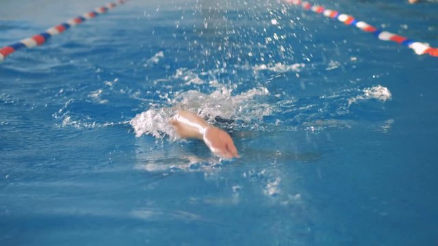 A woman swims backwards in a slow motion.   