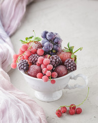Assortment of frozen berries in white cup