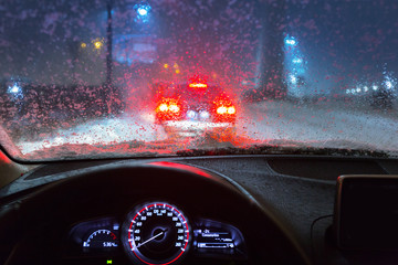 Obraz premium Blurry car silhouette seen through snowy and wet windscreen