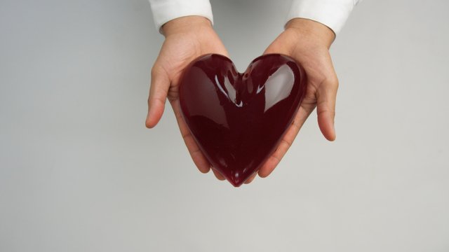 jelly-like red heart in man's hand holding it gently