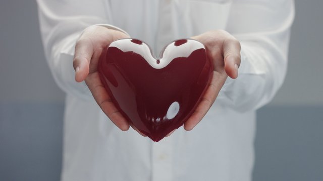 jelly-like red heart in man's hand holding it gently