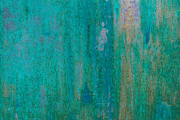 Textured metal surface carelessly colored blue paint and faded in the sun in pale gray with rusty specks.