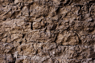 Textured background of a wall of medieval stone masonry. The wall is sloppy built of mountain stones. Medieval style