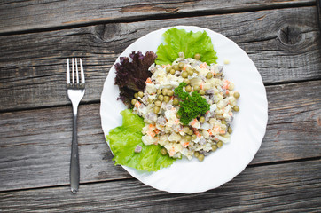Russian winter salad, the lettuce leaf decor brown wooden background.