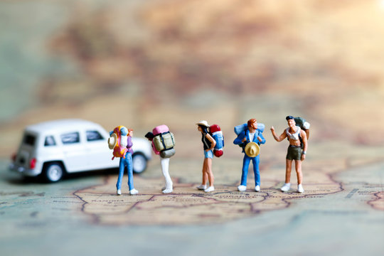 Miniature backpacker on map with car, Concept of Travel around the world and the adventure.