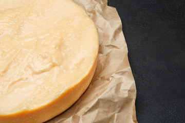 Whole round Head of parmesan or parmigiano hard cheese on concrete background