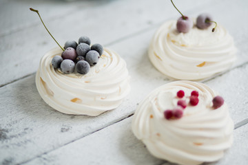 Pavlova cakes with cream and freezed berries. Pastel colors and small bouquet of lavender. Background of white boards. - 191995182