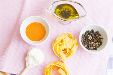 Set of raw ingredients for Italian pasta on a white background. Flour, papper, olive oil. Set of healthy food products. Closeup and top view