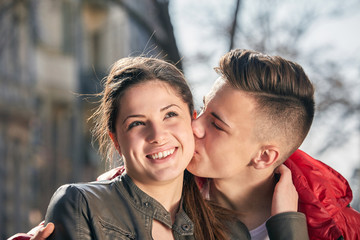 Fototapeta premium young couple kissing on the street in spring