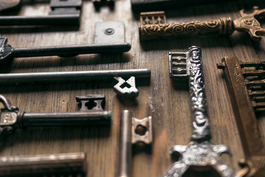 Different vintage metal keys on a wooden background