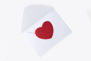 White envelope with  red heart for valentine's day or love mail. Flat lay.  Creative message