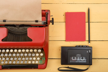 Writer or journalist workplace - vintage red typewriter on the yellow wooden desk
