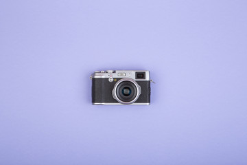 Old fashioned rangefinder camera on purple background, flat view