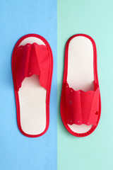 Red one-off slippers for hotel on a colored background