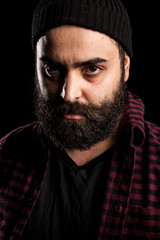 Portrait of bearded man with a hat on black background