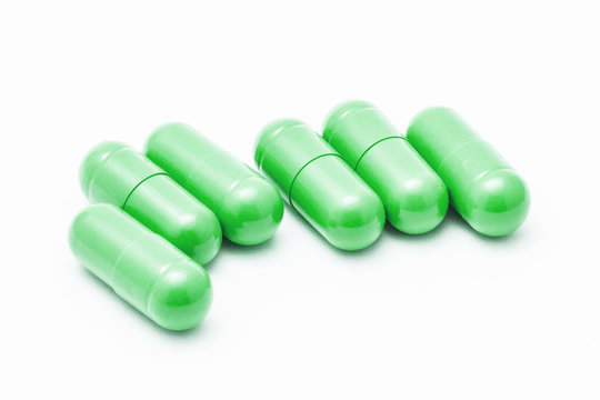Green pills isolated on white.