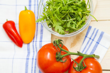 Set of raw ingredients for Italian cooking on a tablecloth background. Salad, tomatos, red and yellow papper. Set of healthy food products. Closeup