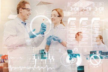 Discussing samples. Clever experienced qualified doctors standing in their big modern laboratory...