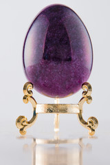 One marble textured stone epensive violet and fashionable easter egg on a gold stand for easter holidays. - 192002330