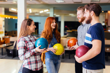 Cheerful friends bowling together
