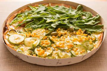 Two flavor pizza: Arugula and zucchini with corn kernels. Detail of meal, closeup, selective focus.