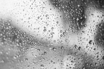 Naklejka na ściany i meble rain water drops on the glass . mirror bokeh background . black and white abstract .