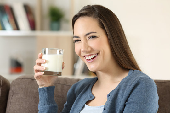 Woman holding a glass of milk looking at camera