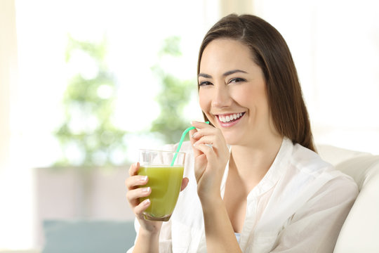 Woman drinking a vegetable juice looking at camera