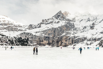 Schlittschuhlaufen auf dem zugefrohrenen Oeschinensee, Kandersteg, Schweiz