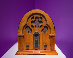 Vintage wood radio from 1930 isolated with purple background.Antique model cathedral.