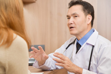 Fototapeta premium Asian Senior male Doctor talking to female patient.