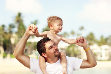 Fototapeta premium Father having fun on the beach with his little son