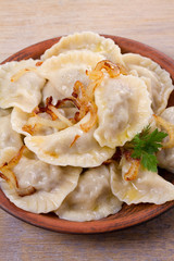 Dumplings, filled with beef meat and served with fried onion. Varenyky, vareniki, pierogi, pyrohy. Dumplings with filling
