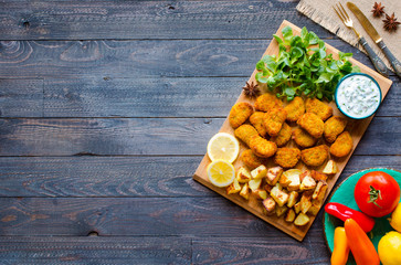 Chicken nuggets with yogurt sauce on a wooden background