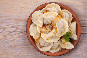 Dumplings, filled with beef meat and served with fried onion. Varenyky, vareniki, pierogi, pyrohy. Dumplings with filling
