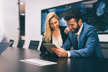 Businesspeople discussing while using digital tablet in office