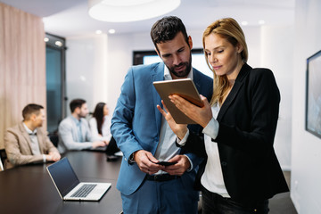 Businesspeople discussing while using digital tablet in office
