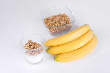 Ingredients for homemade oatmeal granola in glass jar. Oat flakes, honey, raisins and nuts. Healthy breakfast concept with copy