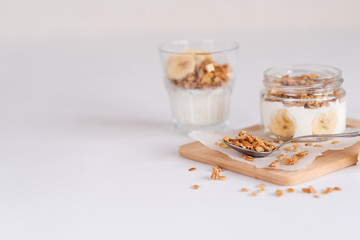 Ingredients for homemade oatmeal granola in glass jar. Oat flakes, honey, raisins and nuts. Healthy breakfast concept with copy