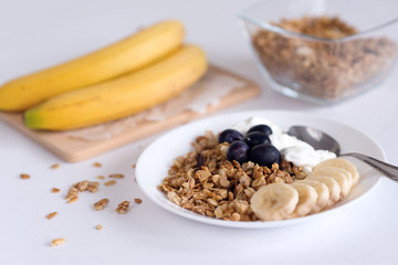 Ingredients for homemade oatmeal granola in glass jar. Oat flakes, honey, raisins and nuts. Healthy breakfast concept with copy
