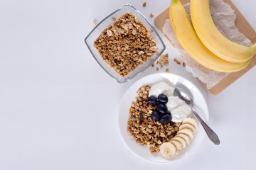 Ingredients for homemade oatmeal granola in glass jar. Oat flakes, honey, raisins and nuts. Healthy breakfast concept with copy