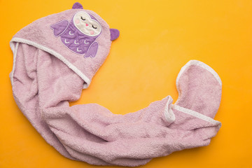 purple  violet bathing baby towel on a yellow background. view f