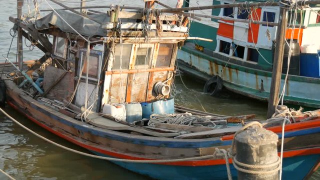 An old wooden half-ruined ship moored on a fishing dock