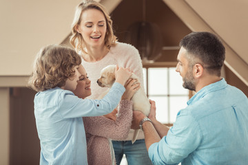 family with adorable labrador puppy in front of cardboard house