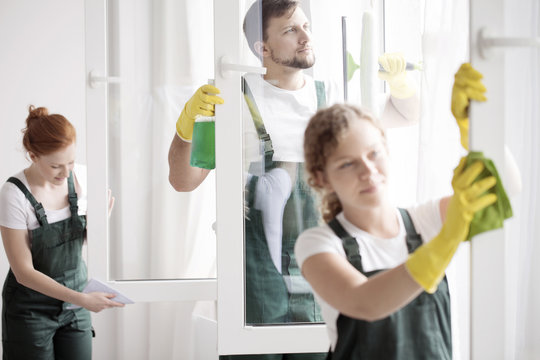 Skilled cleaning team washing windows