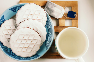 Mug with boiling water, tea bag and cookies