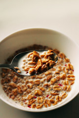 muesli with milk in white plate with spoon