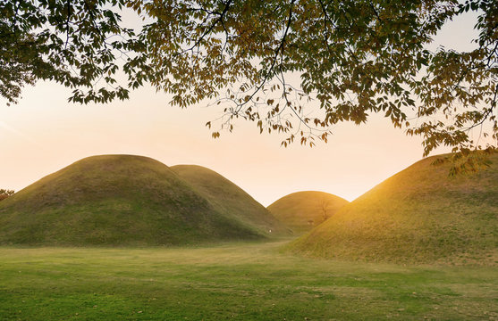 The sunset lights over the Tumuli park royal tombs complex located in Gyeongju, South Korea.