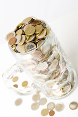 Viele Euromünzen im Glaskrug