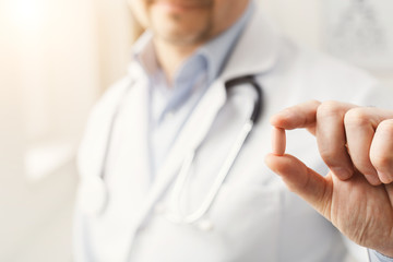 Pill in doctor's hands closeup